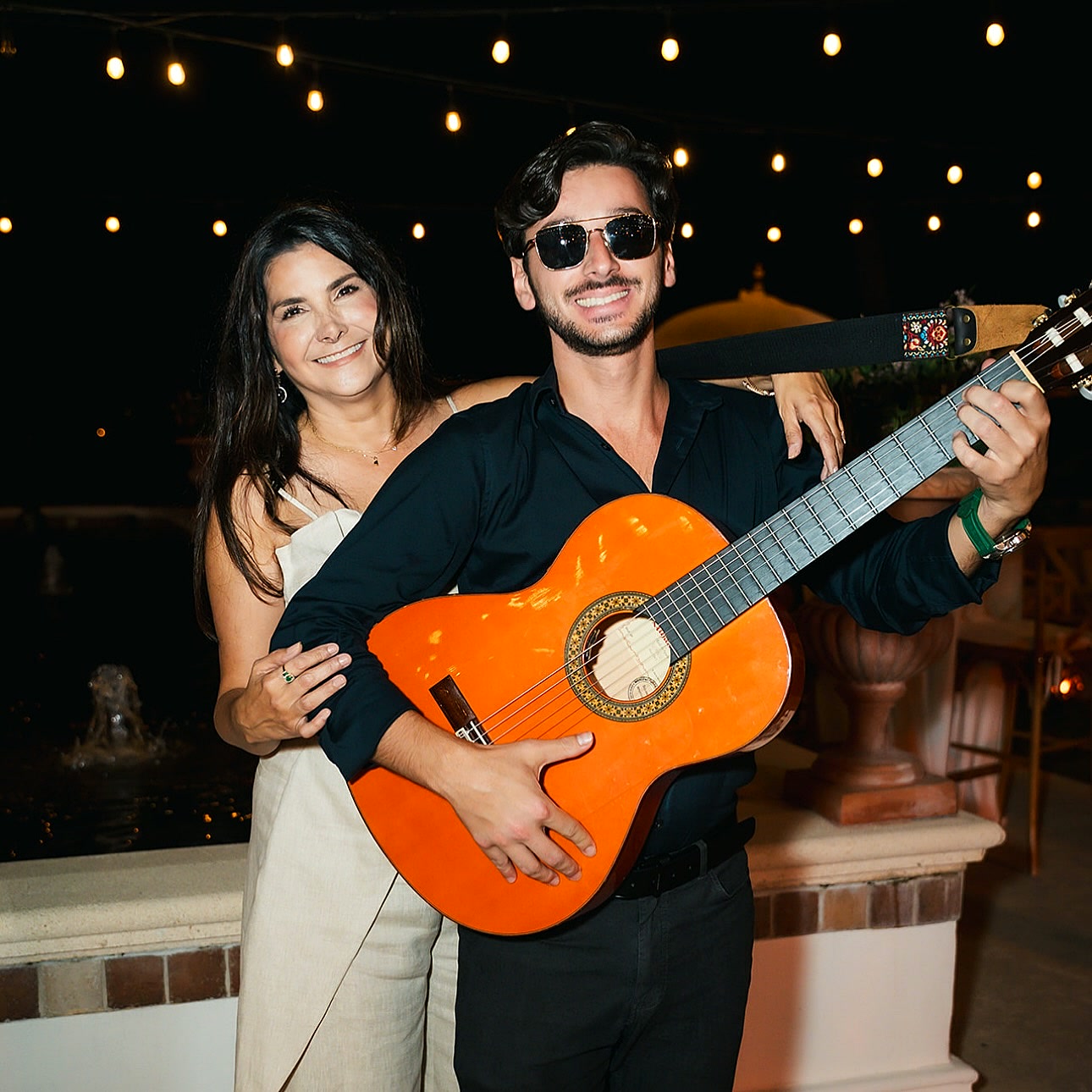 Sergio de Gouveia performing with a guest at a Miami wedding under string lights